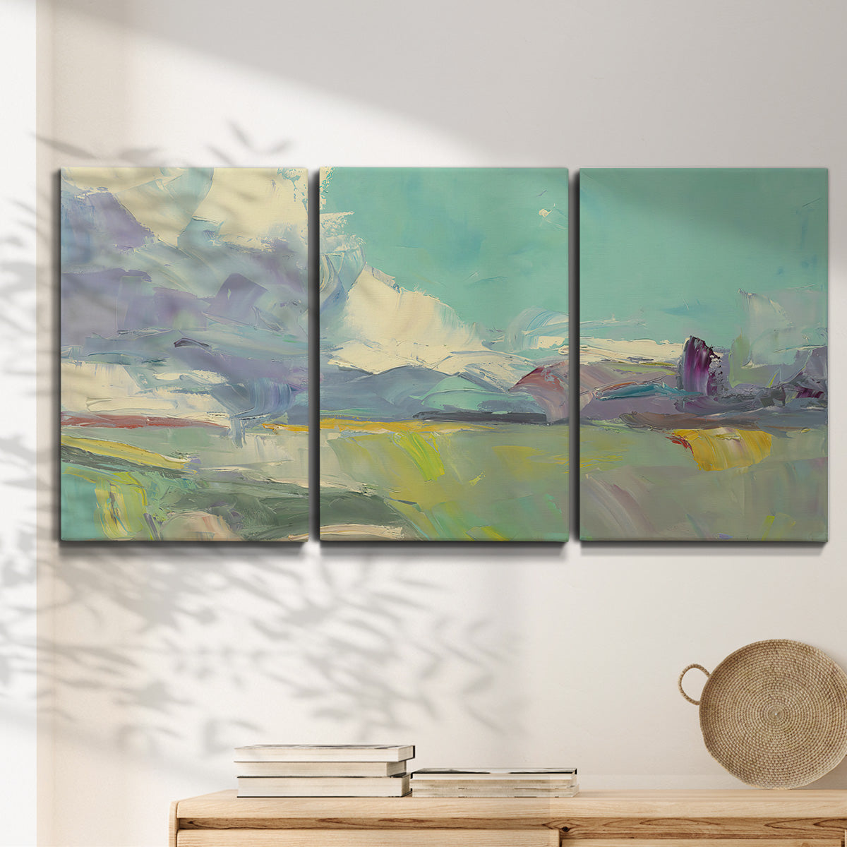Three-panel canvas wall art featuring road stretching through open countryside, displayed in a minimalist living room above a console table.