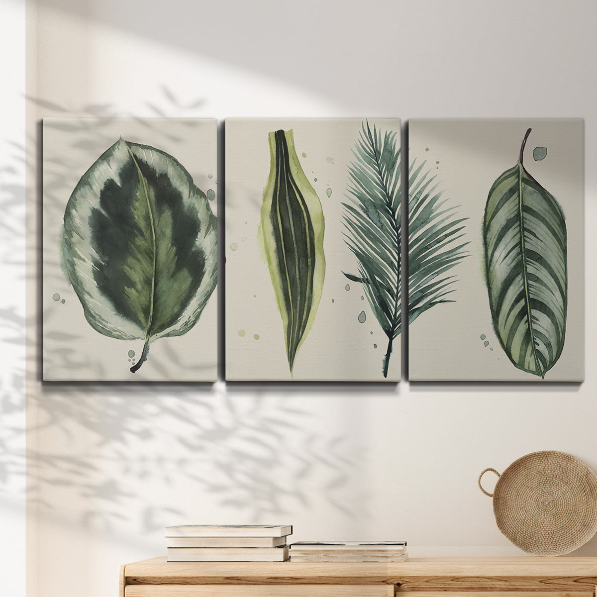 Three-panel canvas wall art featuring botanical palm leaf illustration, displayed in a minimalist living room above a console table.
