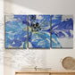 Three-panel canvas wall art featuring blue floral botanical close up, displayed in a minimalist living room above a console table.