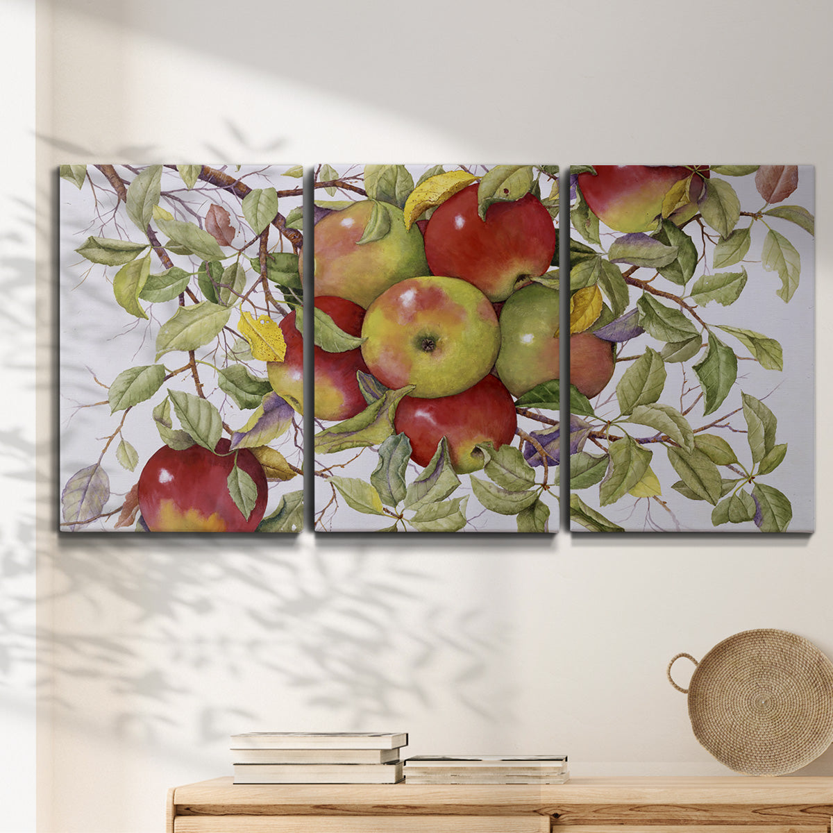 Three-panel canvas wall art featuring apples hanging from branch, displayed in a minimalist living room above a console table.