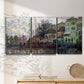 Three-panel canvas wall art featuring riverside town dike at evening, displayed in a minimalist living room above a console table.