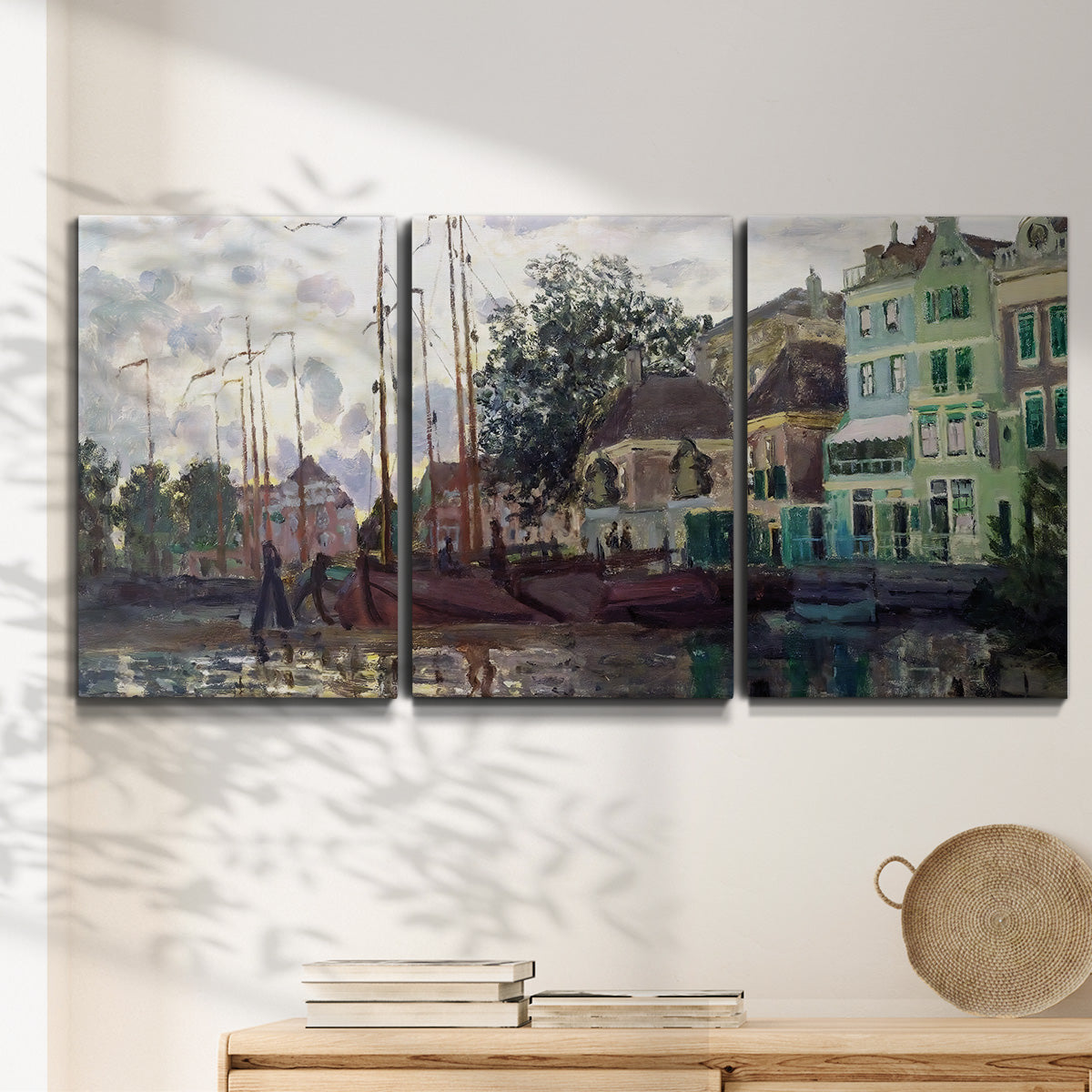 Three-panel canvas wall art featuring riverside town dike at evening, displayed in a minimalist living room above a console table.