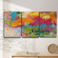 Three-panel canvas wall art featuring expressive abstract sunset tones, displayed in a minimalist living room above a console table.