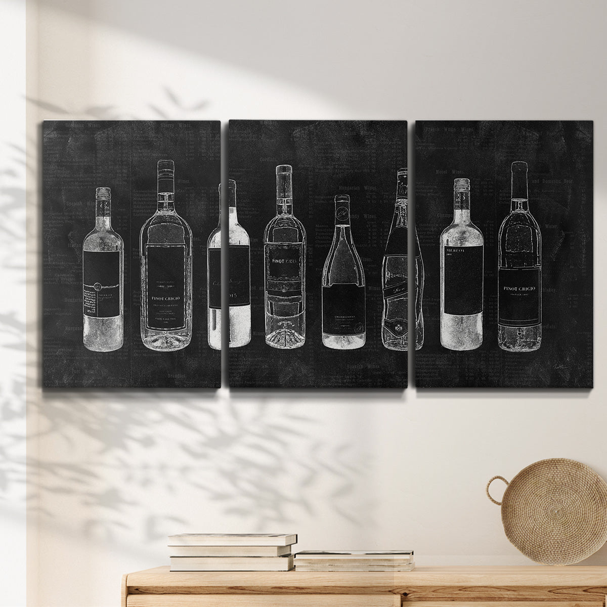 Three-panel canvas wall art featuring illustrated wine bottle cellar diagram, displayed in a minimalist living room above a console table.