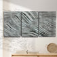 Three-panel canvas wall art featuring coastal shoreline with gentle surf, displayed in a minimalist living room above a console table.