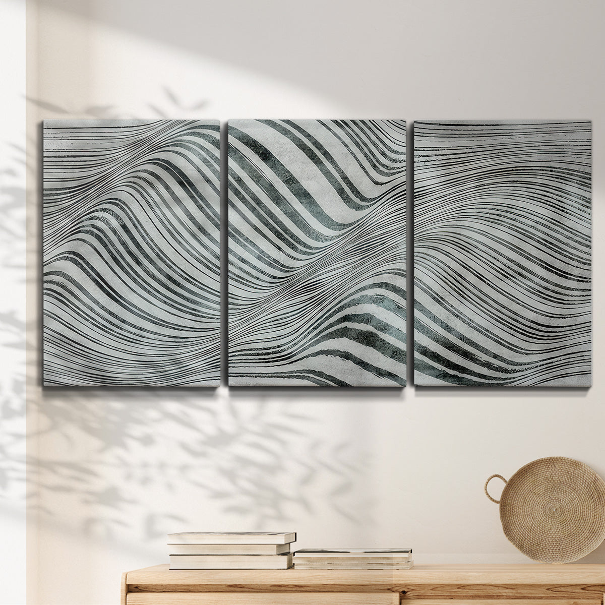 Three-panel canvas wall art featuring coastal shoreline with gentle surf, displayed in a minimalist living room above a console table.