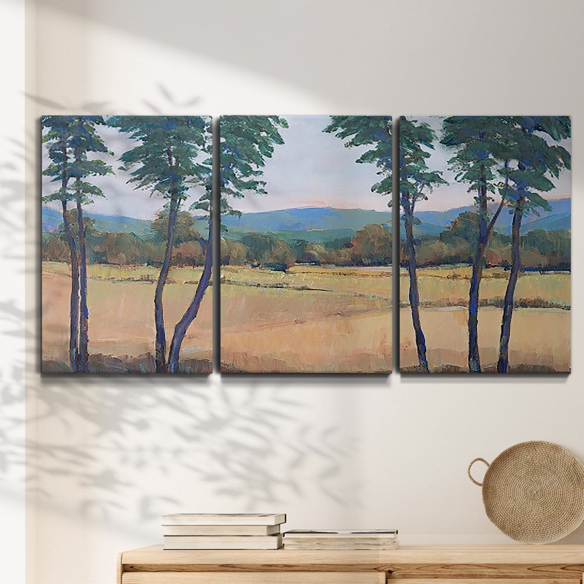 Three-panel canvas wall art featuring quiet morning landscape with trees, displayed in a minimalist living room above a console table.