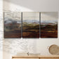 Three-panel canvas wall art featuring rustic abstract landscape exploration, displayed in a minimalist living room above a console table.