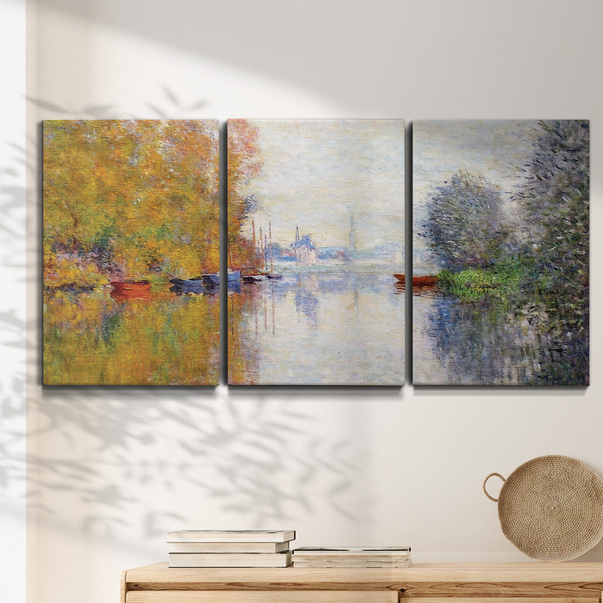 Three-panel canvas wall art featuring golden autumn light over riverside, displayed in a minimalist living room above a console table.