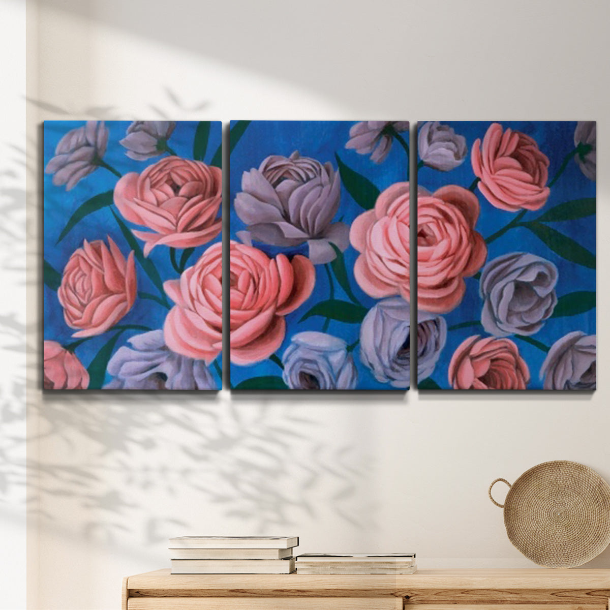Three-panel canvas wall art featuring layered botanical petal abstractions, displayed in a minimalist living room above a console table.