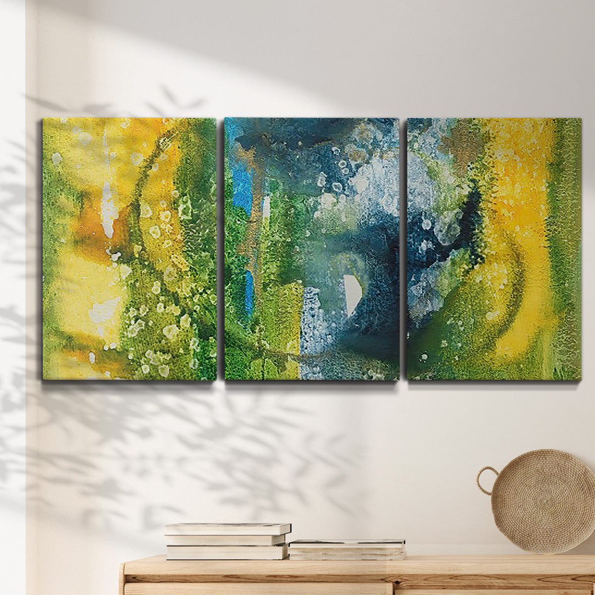 Three-panel canvas wall art featuring energetic abstract aquatic color motion, displayed in a minimalist living room above a console table.