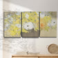 Three-panel canvas wall art featuring abstract floral table arrangement, displayed in a minimalist living room above a console table.
