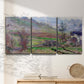 Three-panel canvas wall art featuring cliffside cottage overlooking sea, displayed in a minimalist living room above a console table.