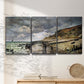 Three-panel canvas wall art featuring sunset beach with glowing sky, displayed in a minimalist living room above a console table.