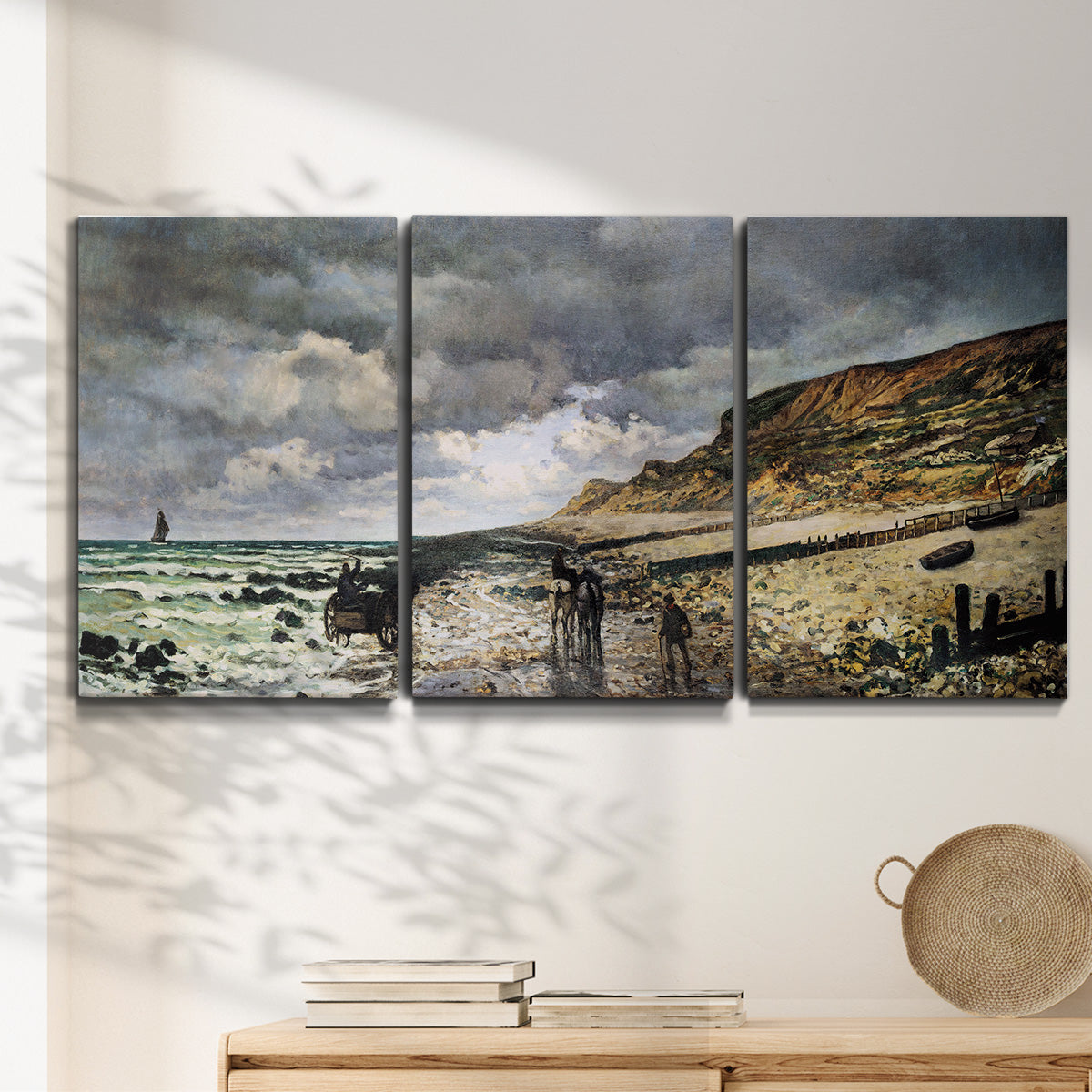 Three-panel canvas wall art featuring sunset beach with glowing sky, displayed in a minimalist living room above a console table.