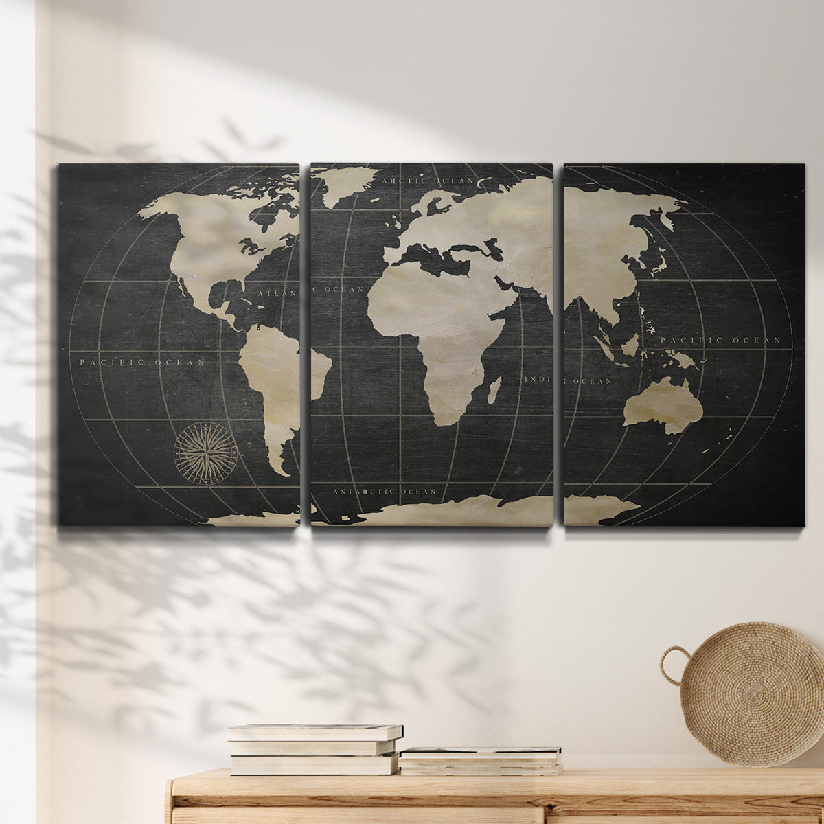 Three-panel canvas wall art featuring antique world map illustration, displayed in a minimalist living room above a console table.