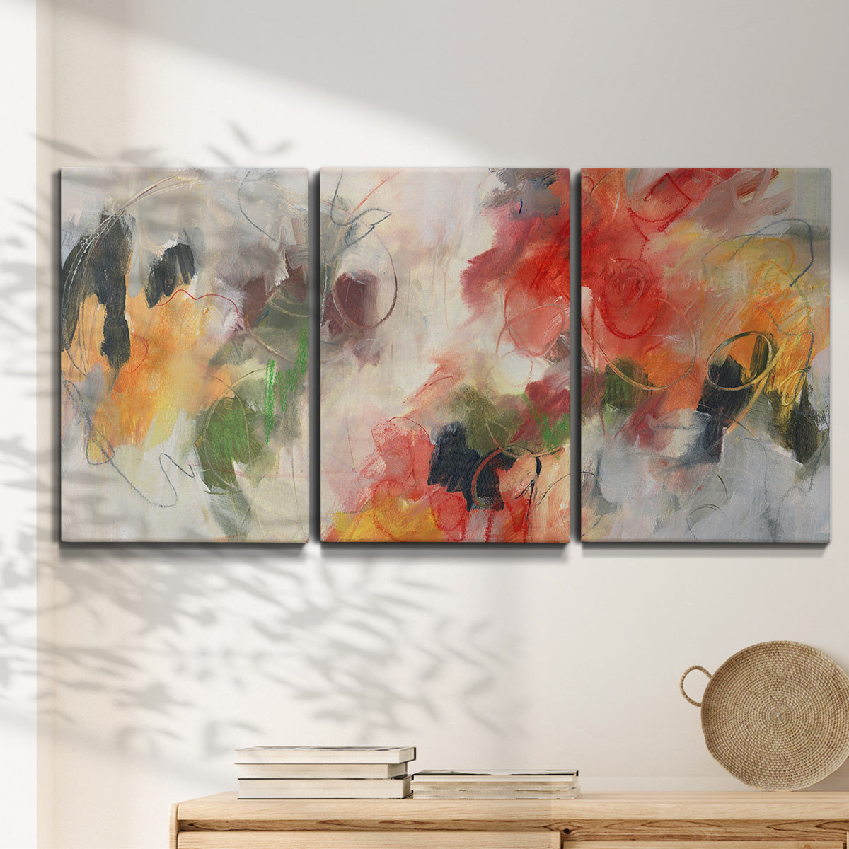 Three-panel canvas wall art featuring abstract floral color composition, displayed in a minimalist living room above a console table.