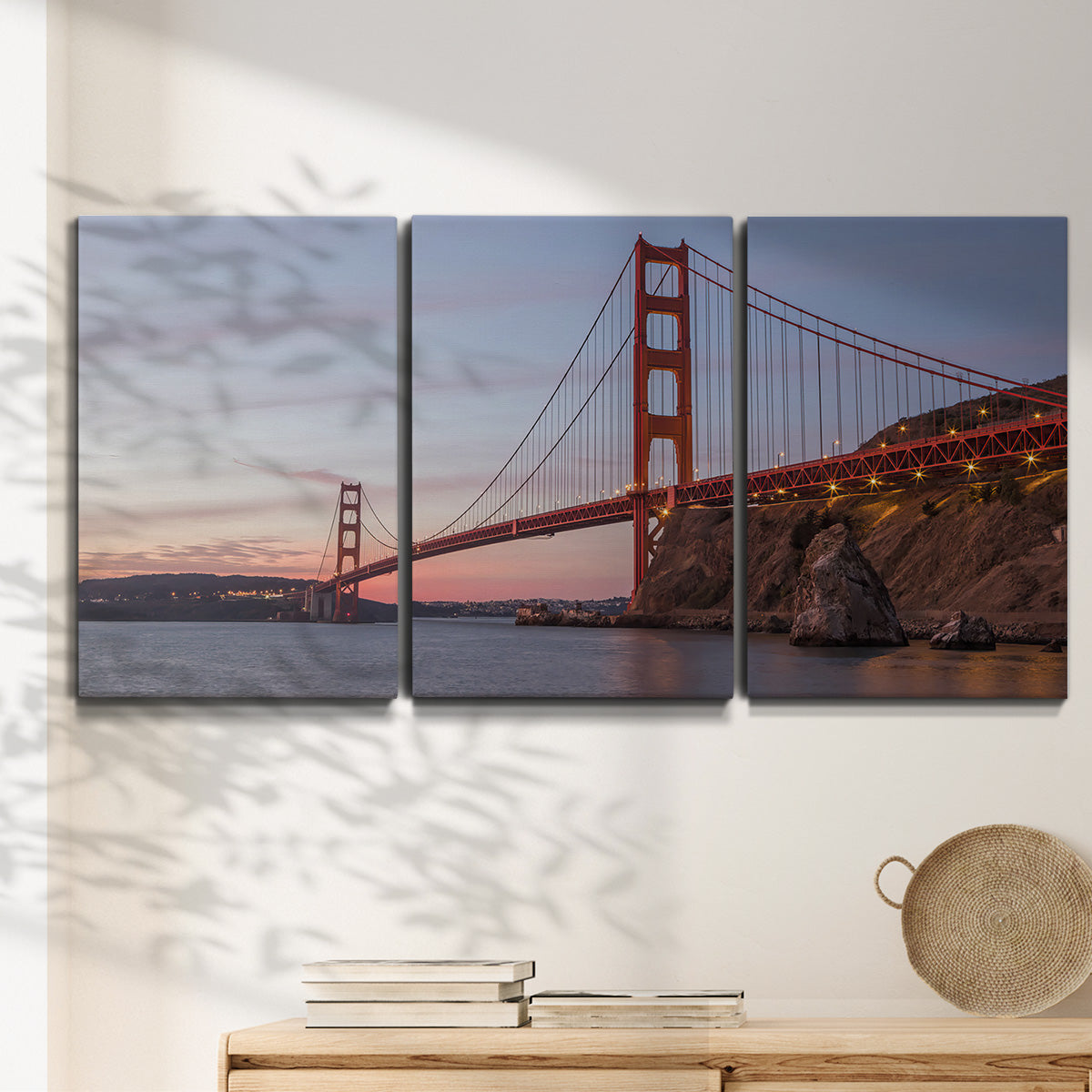 Three-panel canvas wall art featuring golden gate bridge spanning bay, displayed in a minimalist living room above a console table.