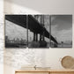 Three-panel canvas wall art featuring manhattan bridge industrial cityscape, displayed in a minimalist living room above a console table.