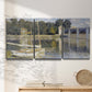 Three-panel canvas wall art featuring bridge crossing broad river, displayed in a minimalist living room above a console table.