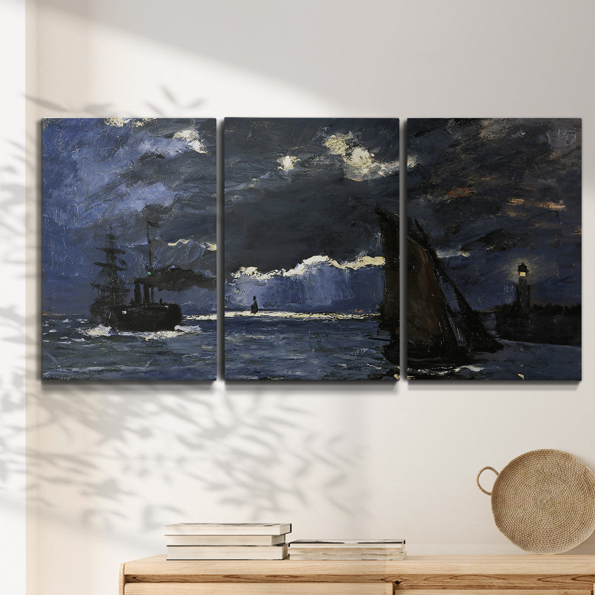 Three-panel canvas wall art featuring dark seascape under night sky, displayed in a minimalist living room above a console table.
