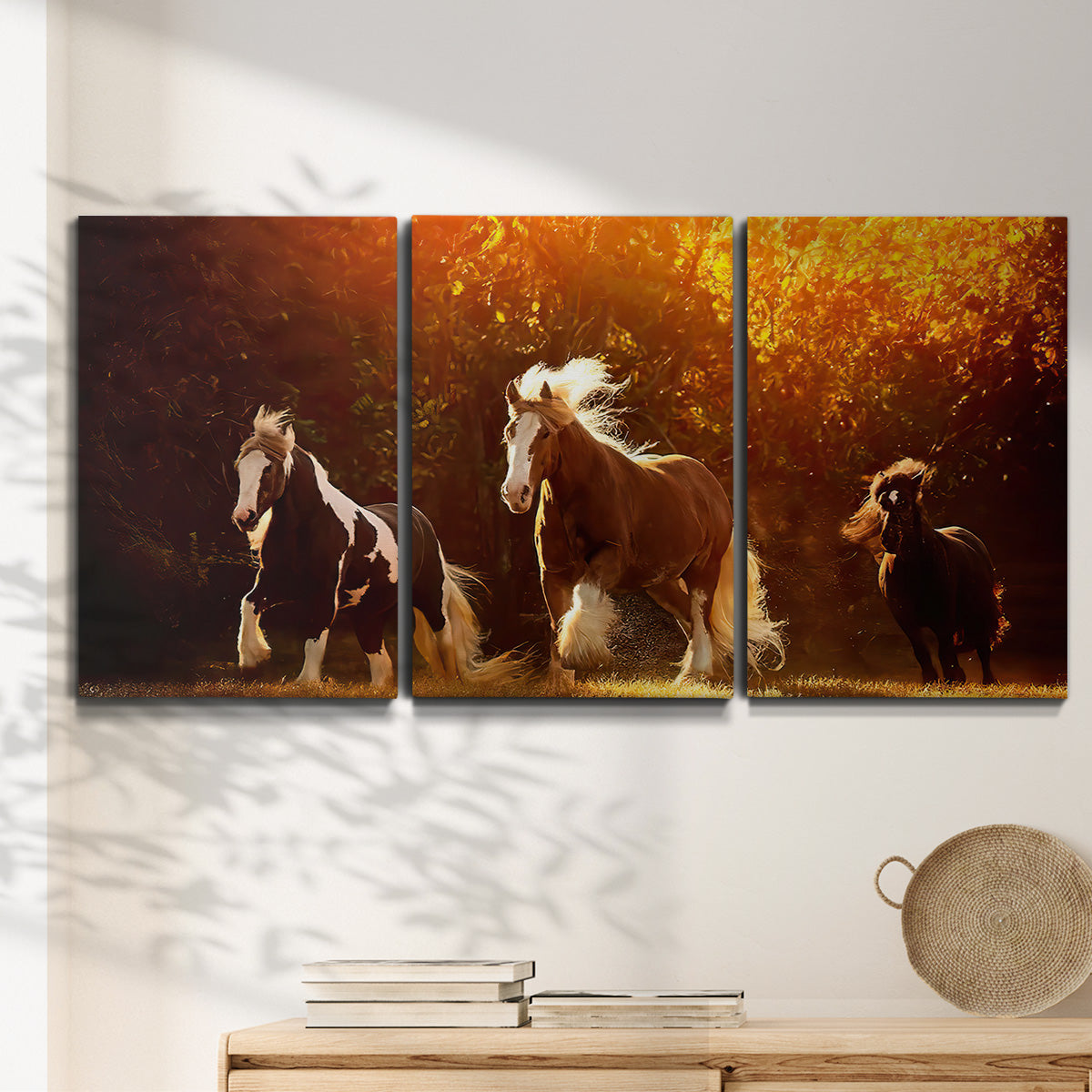 Three-panel canvas wall art featuring running horses across open field, displayed in a minimalist living room above a console table.
