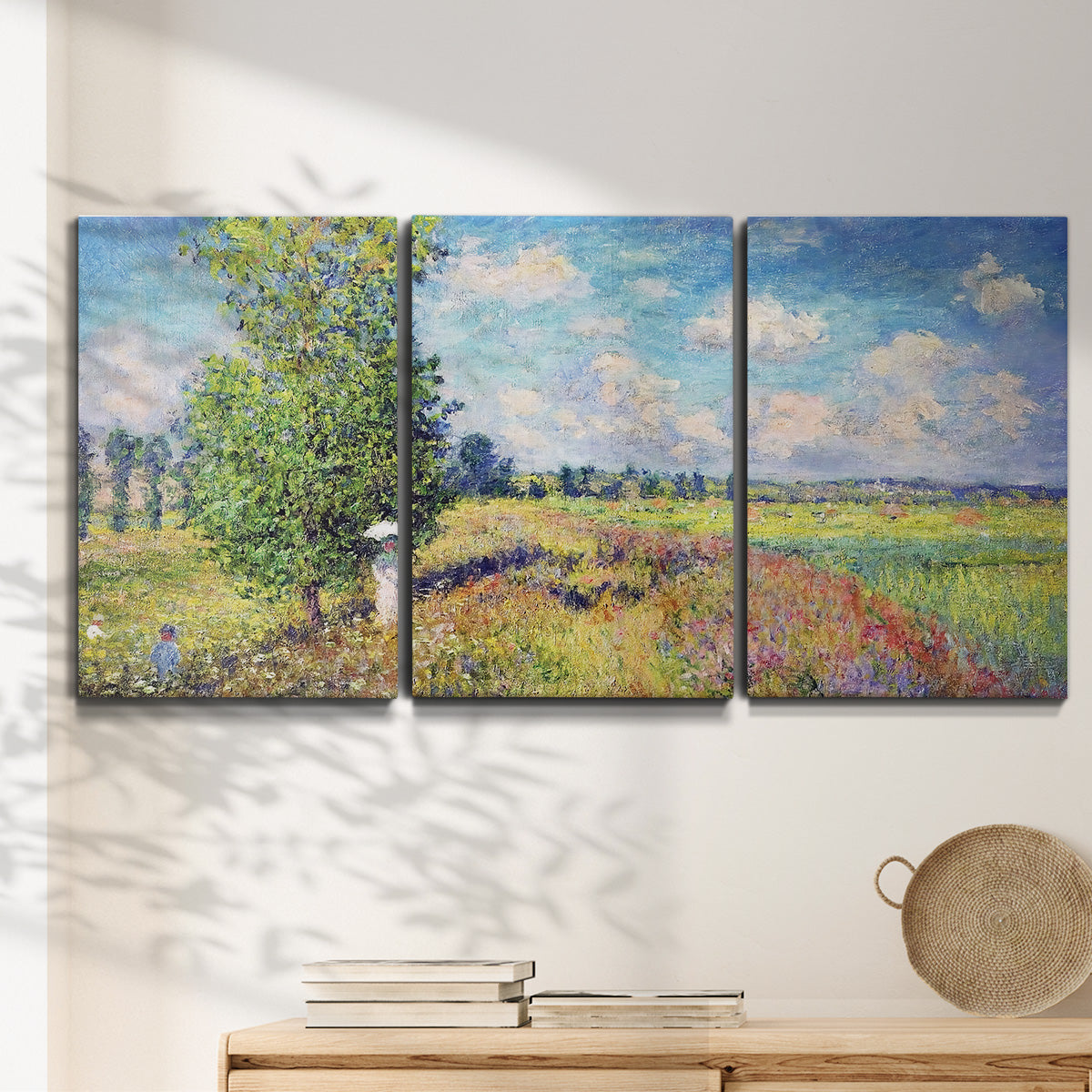 Three-panel canvas wall art featuring sunlit meadow landscape, displayed in a minimalist living room above a console table.