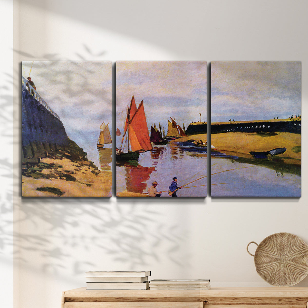 Three-panel canvas wall art featuring stone breakwater at low tide, displayed in a minimalist living room above a console table.