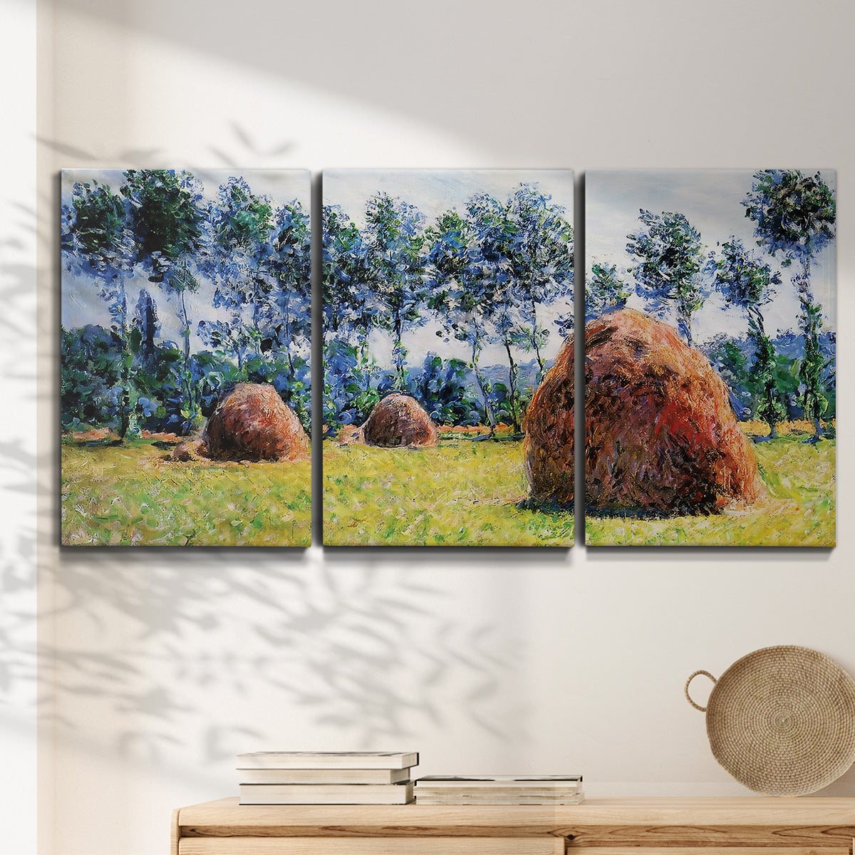 Three-panel canvas wall art featuring harvested grainstacks in field, displayed in a minimalist living room above a console table.
