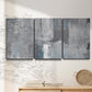 Three-panel canvas wall art featuring cool toned industrial abstract blues, displayed in a minimalist living room above a console table.