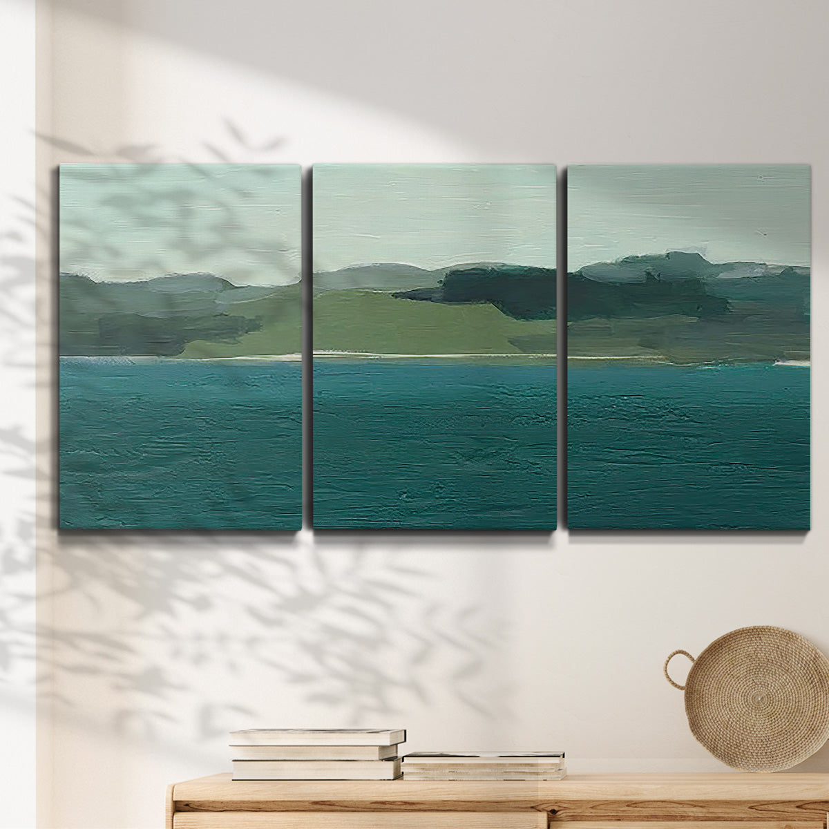 Three-panel canvas wall art featuring calm lake water under open sky, displayed in a minimalist living room above a console table.