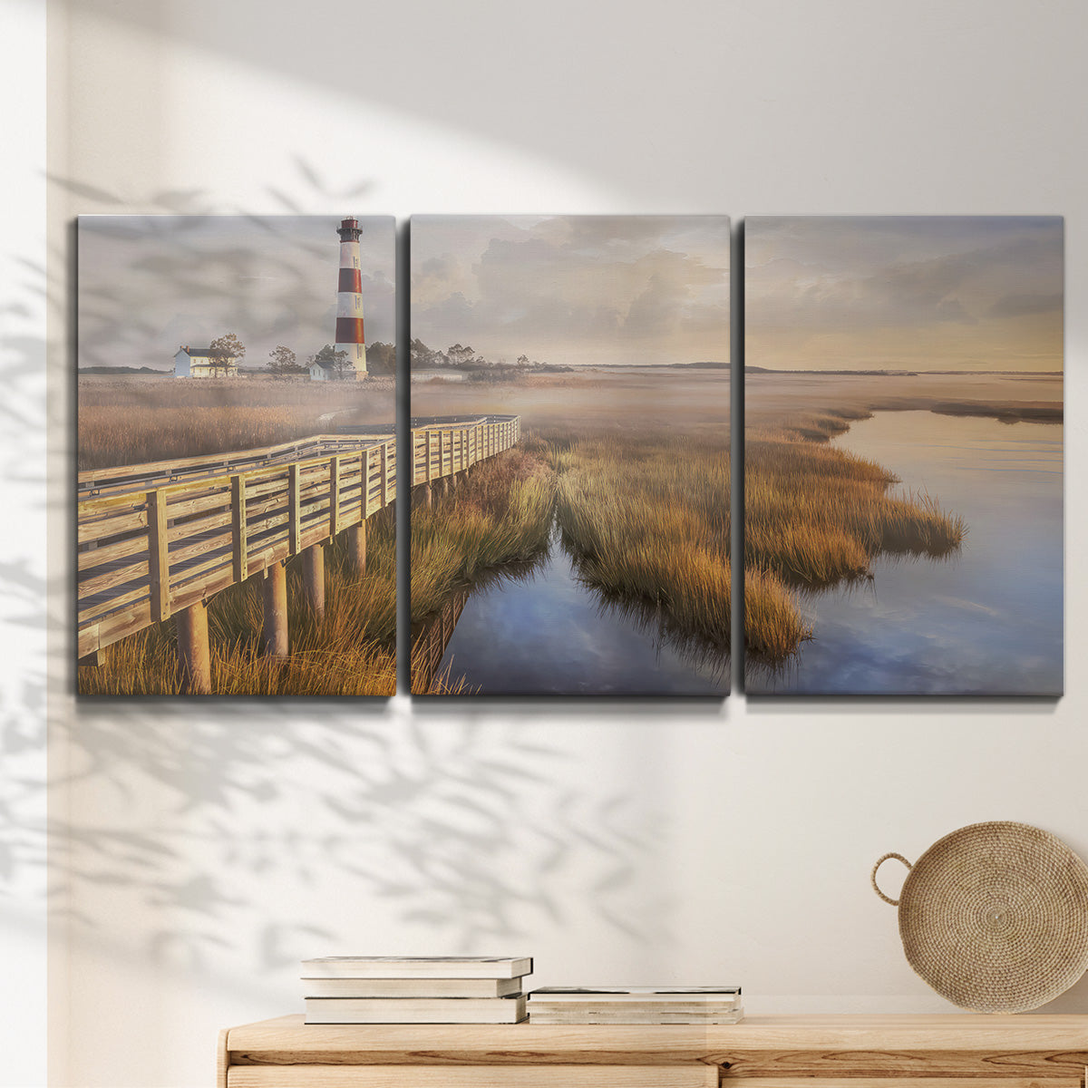 Three-panel canvas wall art featuring coastal path along dunes, displayed in a minimalist living room above a console table.