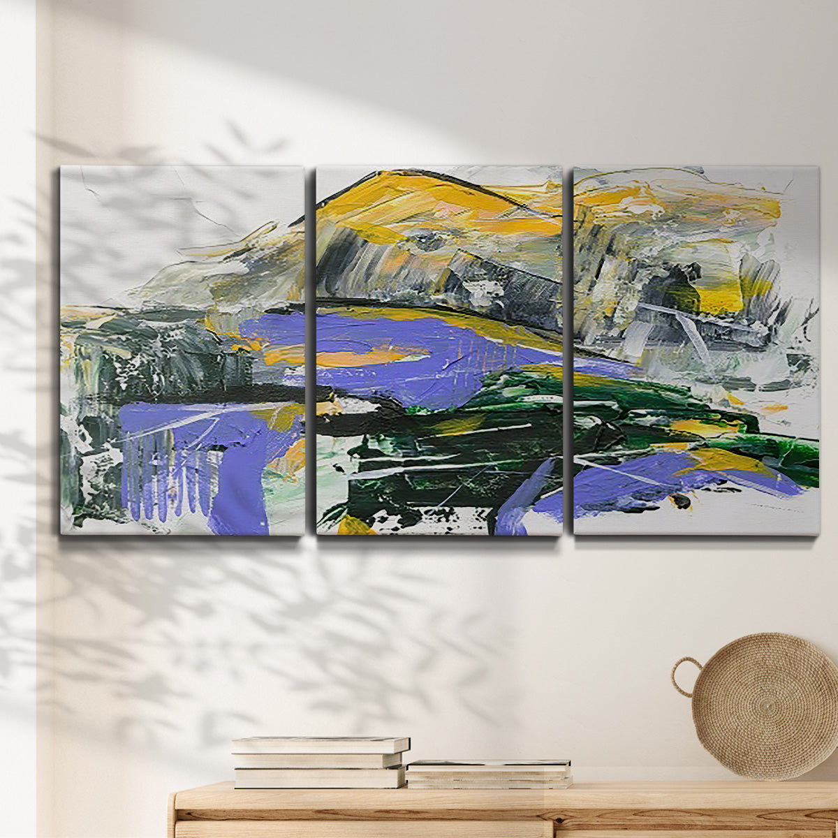 Three-panel canvas wall art featuring quiet abstract mountain silhouette, displayed in a minimalist living room above a console table.
