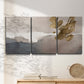 Three-panel canvas wall art featuring abstract watercolor with gold accents, displayed in a minimalist living room above a console table.