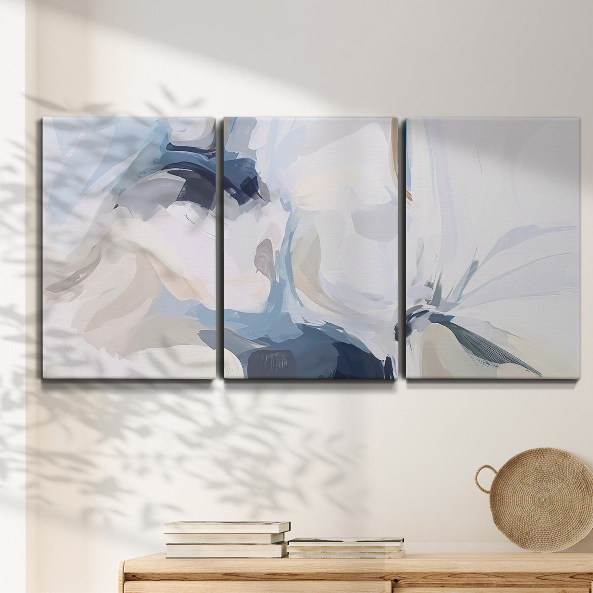 Three-panel canvas wall art featuring airy abstract movement composition, displayed in a minimalist living room above a console table.
