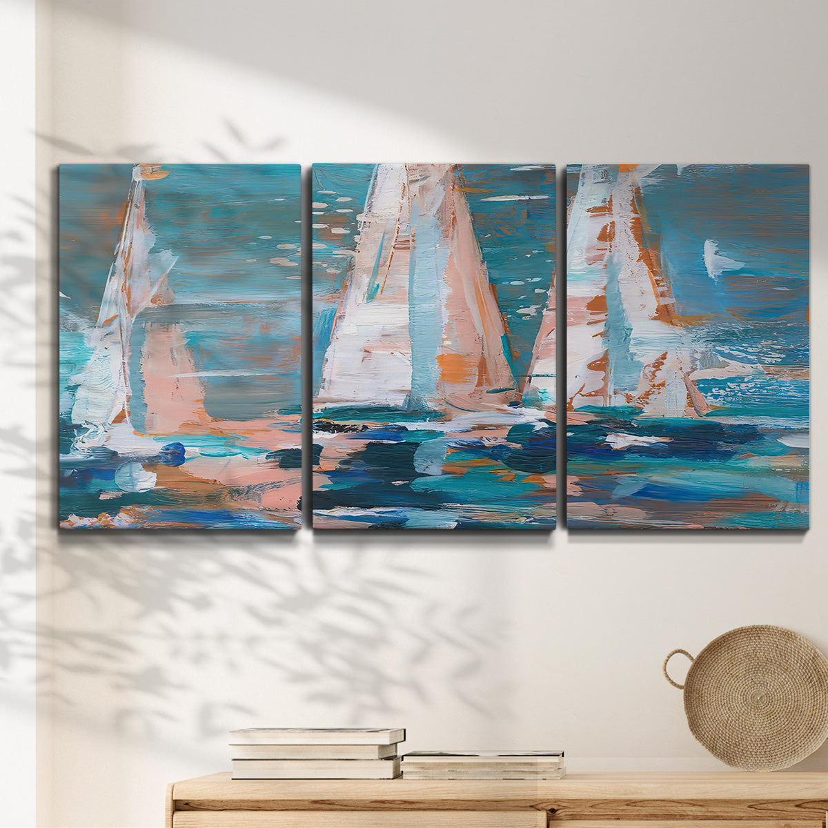Three-panel canvas wall art featuring graphic pop style sailboats, displayed in a minimalist living room above a console table.