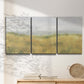 Three-panel canvas wall art featuring pastoral wheat field landscape, displayed in a minimalist living room above a console table.