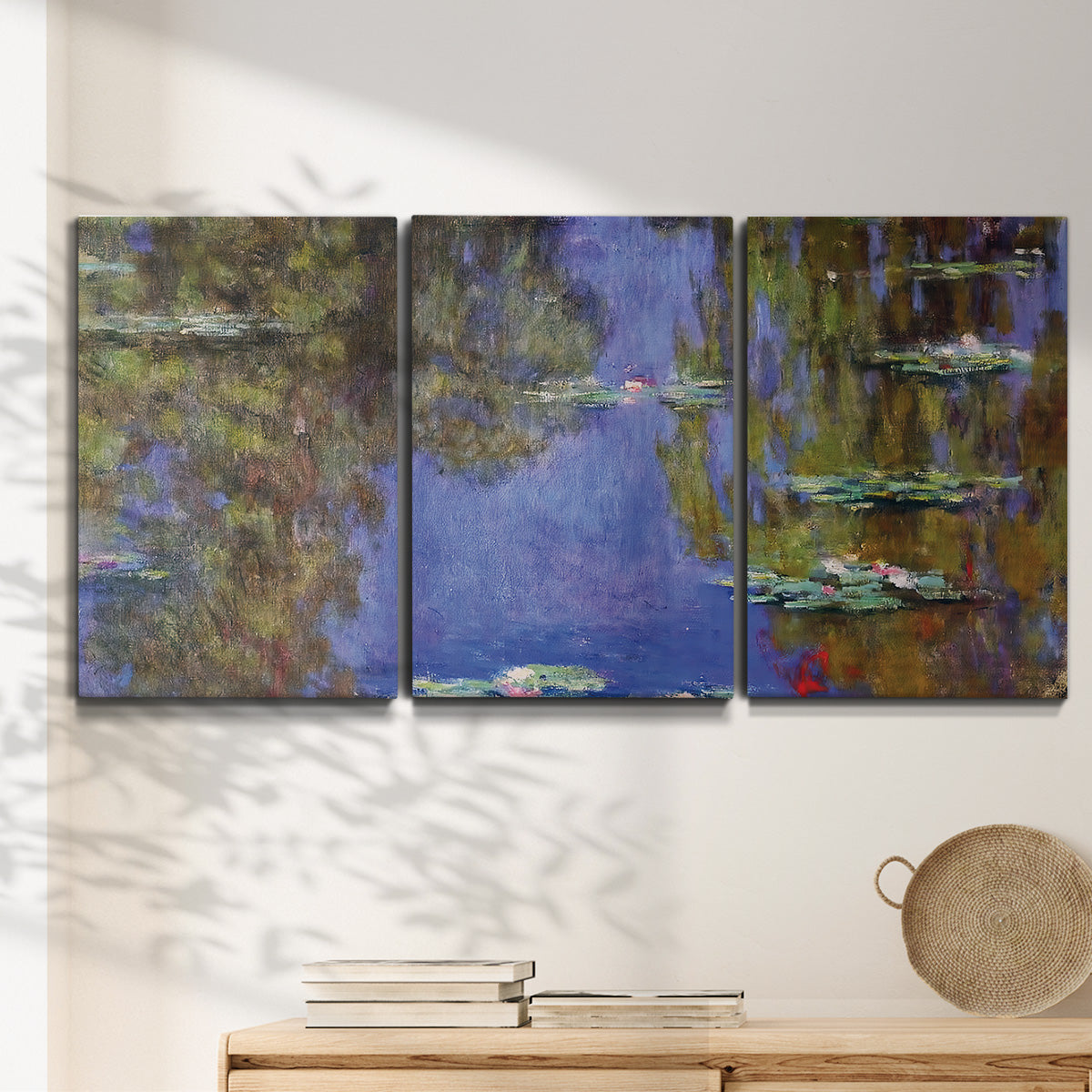 Three-panel canvas wall art featuring blue and purple water lily pond, displayed in a minimalist living room above a console table.