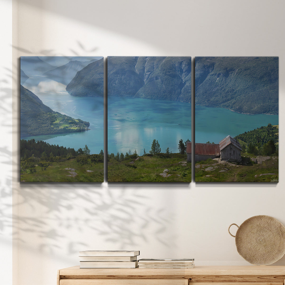Three-panel canvas wall art featuring symmetrical water reflections with trees, displayed in a minimalist living room above a console table.