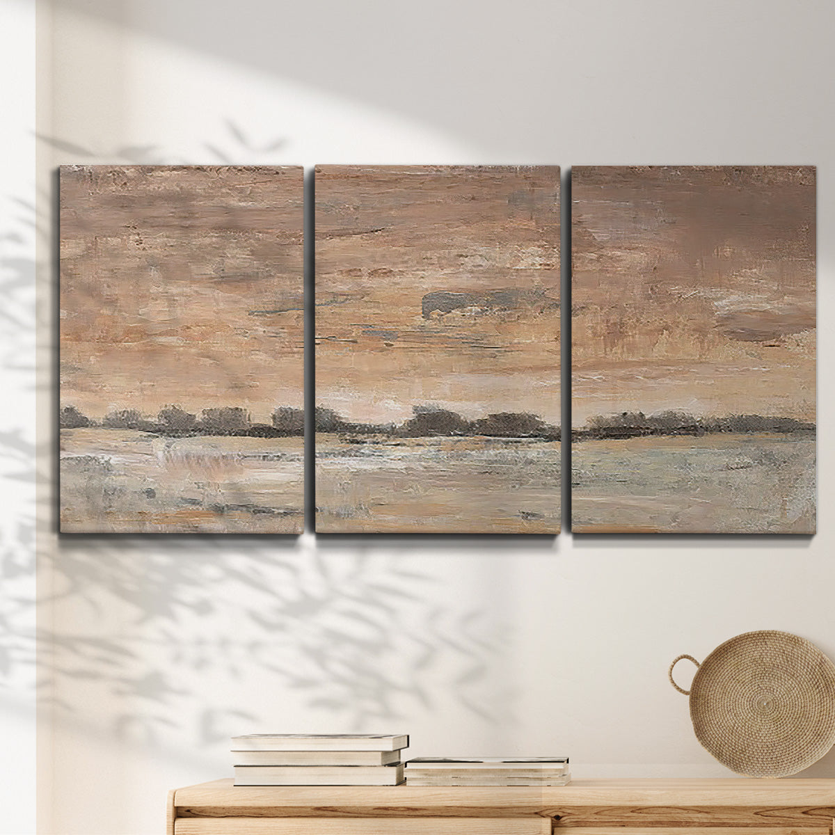 Three-panel canvas wall art featuring soft early evening landscape light, displayed in a minimalist living room above a console table.