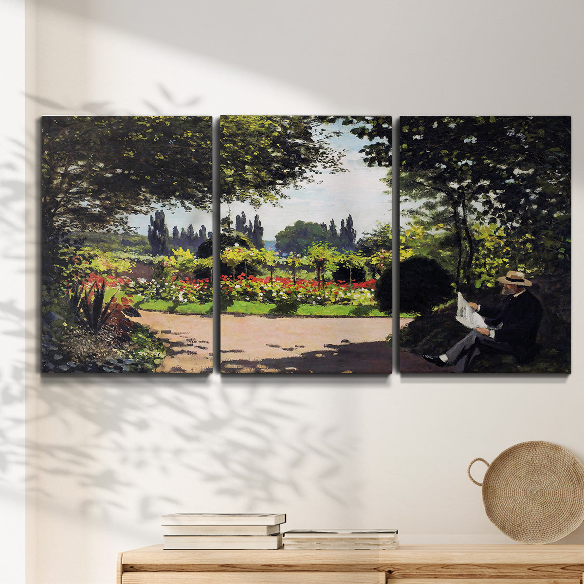 Three-panel canvas wall art featuring coastal garden overlooking sea, displayed in a minimalist living room above a console table.