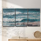 Three-panel canvas wall art featuring crashing ocean waves along shoreline, displayed in a minimalist living room above a console table.