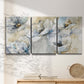 Three-panel canvas wall art featuring delicate watercolor floral blooms, displayed in a minimalist living room above a console table.
