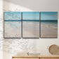 Three-panel canvas wall art featuring white sand beach with gentle waves, displayed in a minimalist living room above a console table.