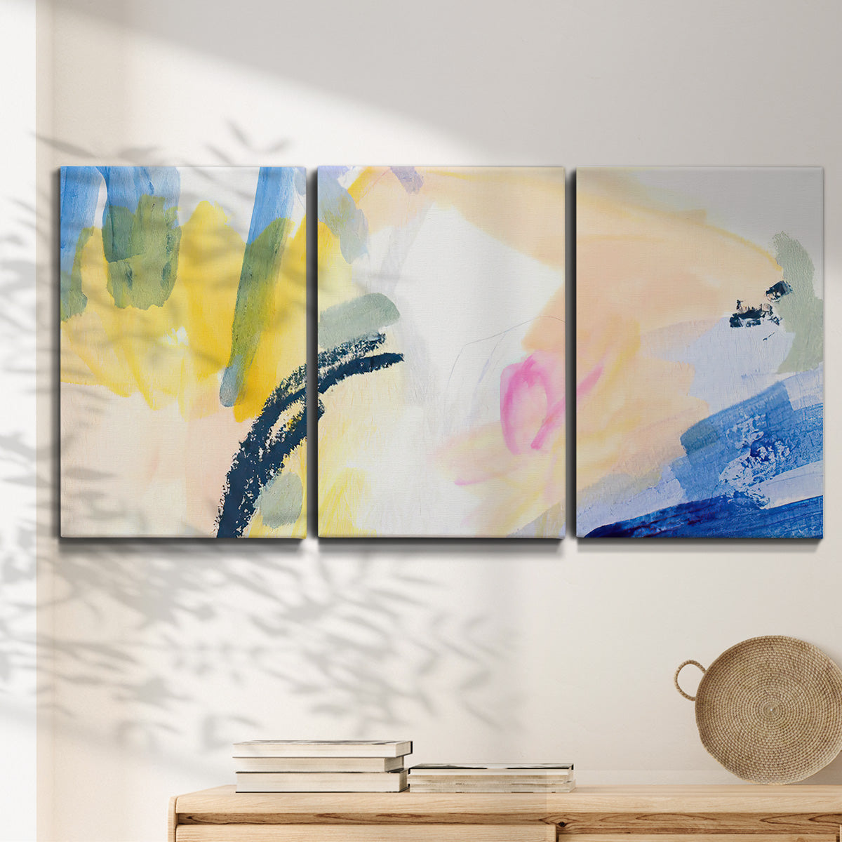 Three-panel canvas wall art featuring bright abstract candy colored strokes, displayed in a minimalist living room above a console table.