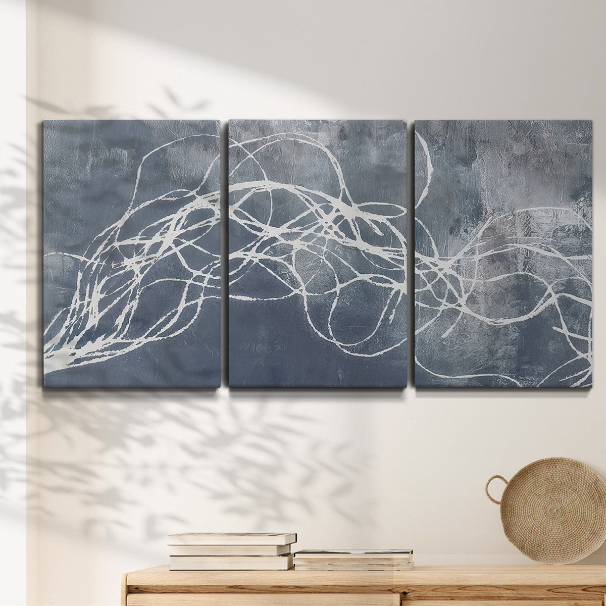 Three-panel canvas wall art featuring coastal shoreline at golden hour, displayed in a minimalist living room above a console table.