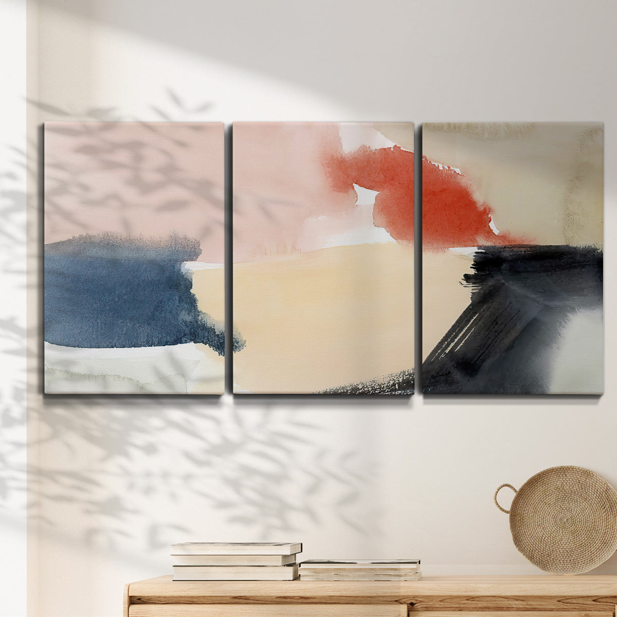 Three-panel canvas wall art featuring playful abstract watercolor shapes, displayed in a minimalist living room above a console table.