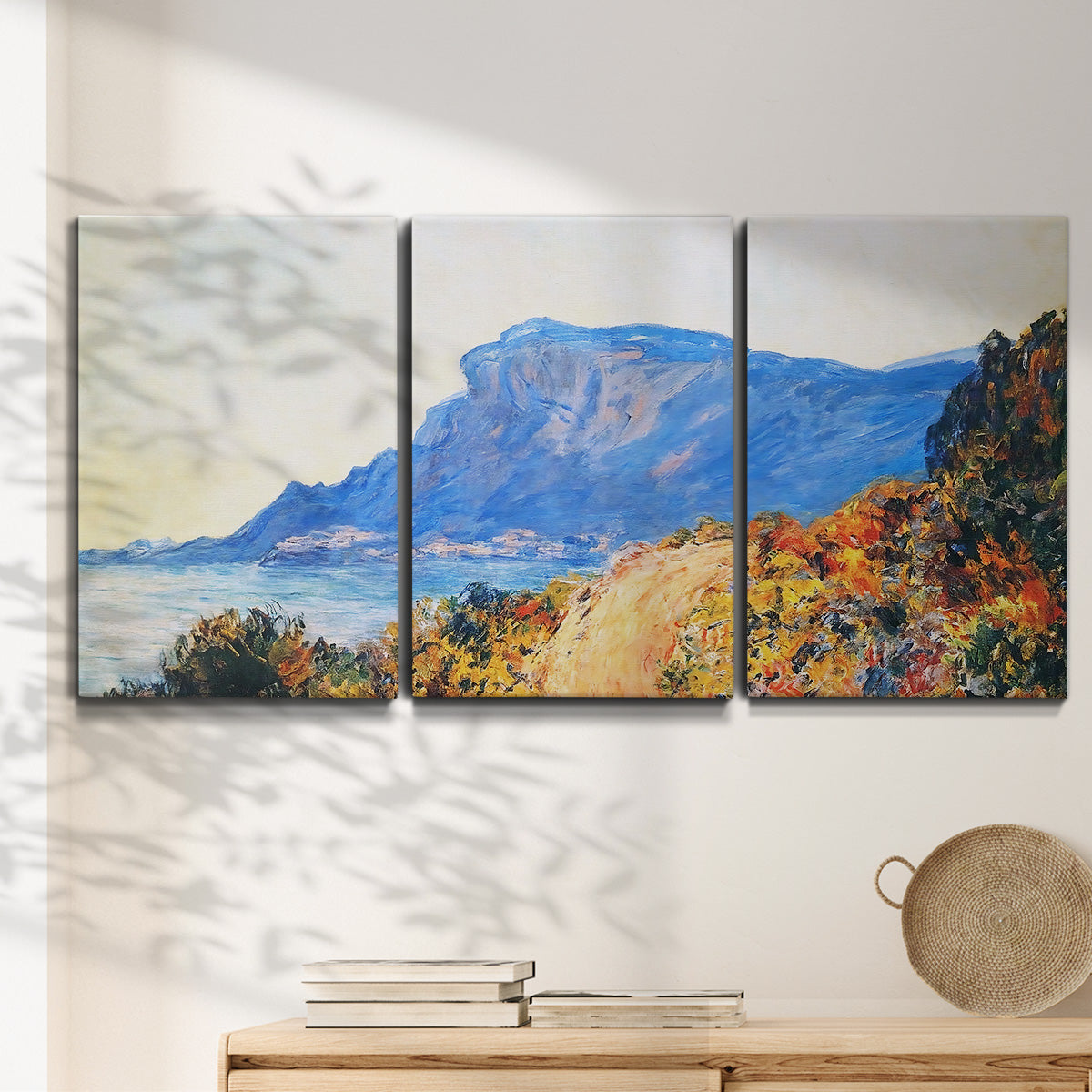 Three-panel canvas wall art featuring winding red road hillside, displayed in a minimalist living room above a console table.