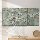 Three-panel canvas wall art featuring delicate spring blossoms with birds, displayed in a minimalist living room above a console table.