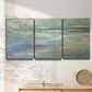 Three-panel canvas wall art featuring soft coastal beach light landscape, displayed in a minimalist living room above a console table.